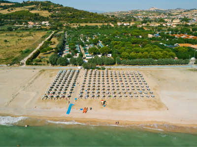 Spiaggia con ombrelloni e mare, vista dall'alto.