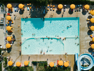 Vista dall'alto di una piscina con ombrelloni arancioni.