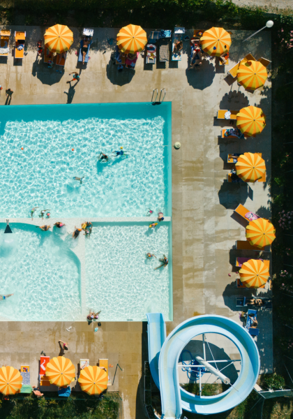 Aerial view of a pool with orange umbrellas.