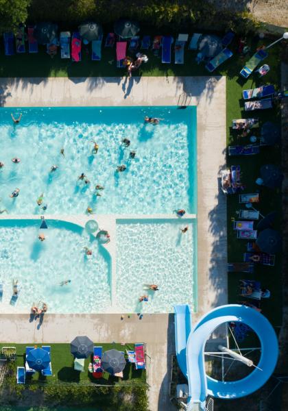 Aerial view of a crowded pool with a water slide.