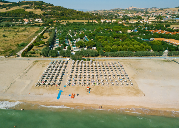 Spiaggia con ombrelloni e mare, vista dall'alto.