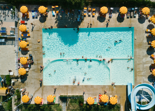 Vista dall'alto di una piscina con ombrelloni arancioni.