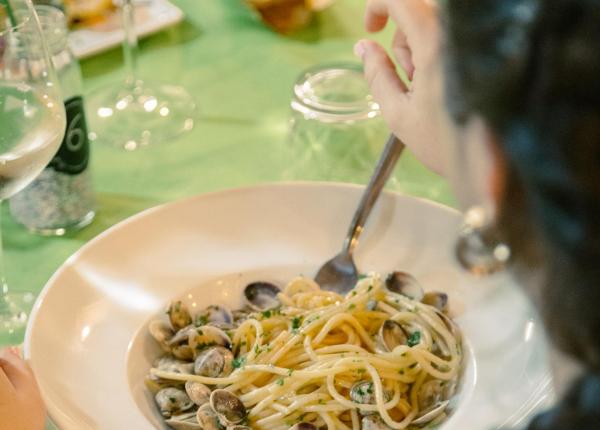 Plate of spaghetti with clams on a set table.